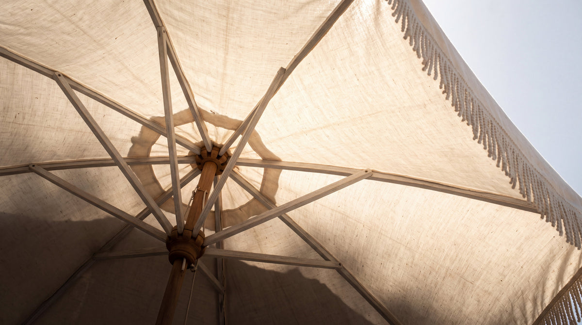 Looking up through a linen beach umbrella glowing in midday sun, being skin smart with tattoos